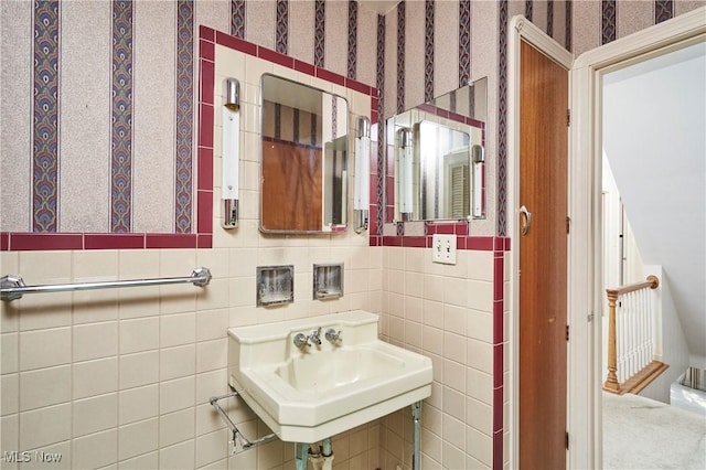 bathroom with wallpapered walls and a sink