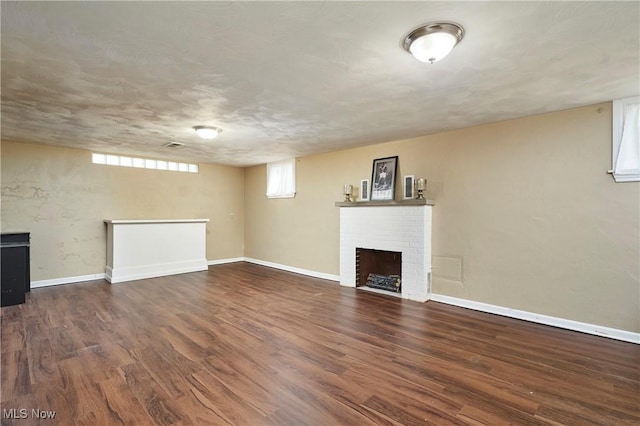 below grade area with baseboards, wood finished floors, and a fireplace
