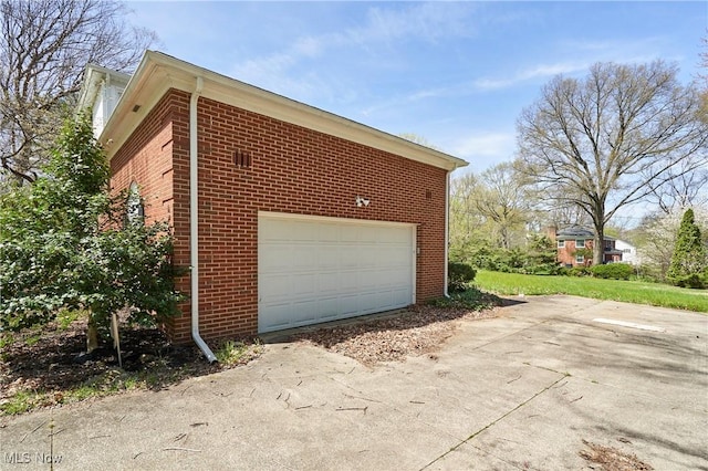 view of side of home with a garage and brick siding