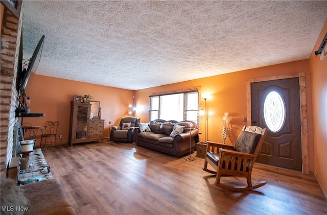 living area featuring a textured ceiling, a healthy amount of sunlight, and wood finished floors