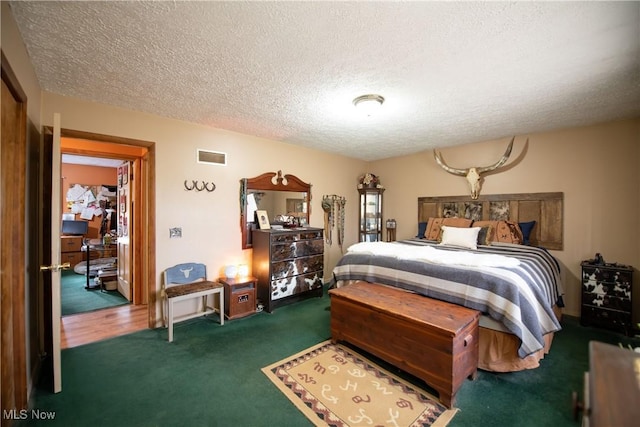 carpeted bedroom featuring a textured ceiling and visible vents