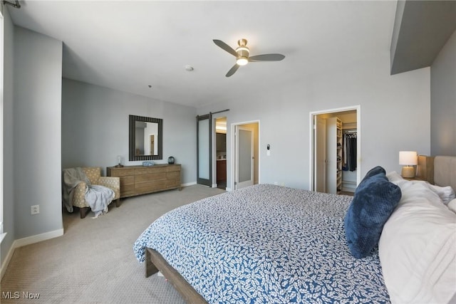 carpeted bedroom with baseboards, a spacious closet, and a ceiling fan