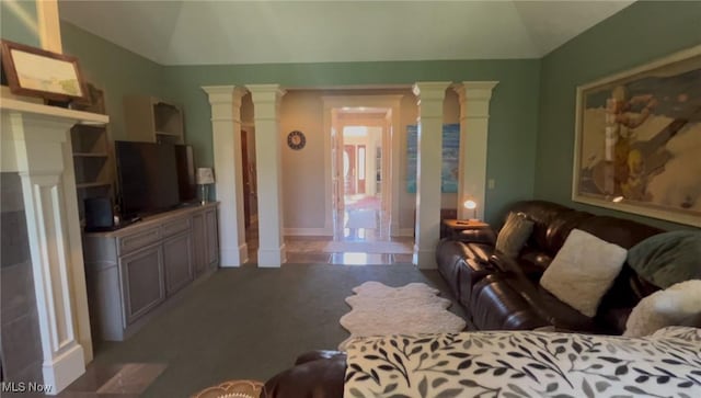 carpeted living room with vaulted ceiling and decorative columns