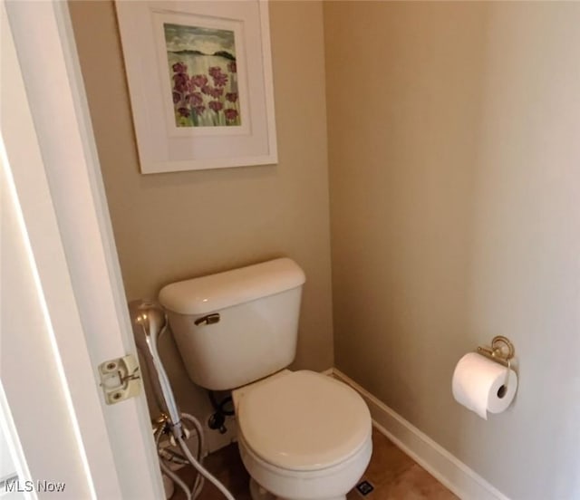 bathroom featuring toilet, tile patterned floors, and baseboards
