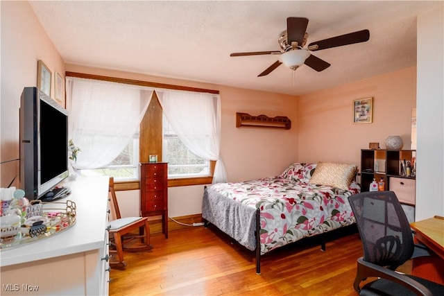 bedroom with ceiling fan and light wood-style flooring