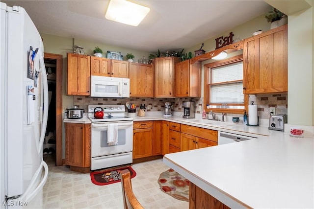 kitchen with light countertops, a sink, backsplash, and white appliances
