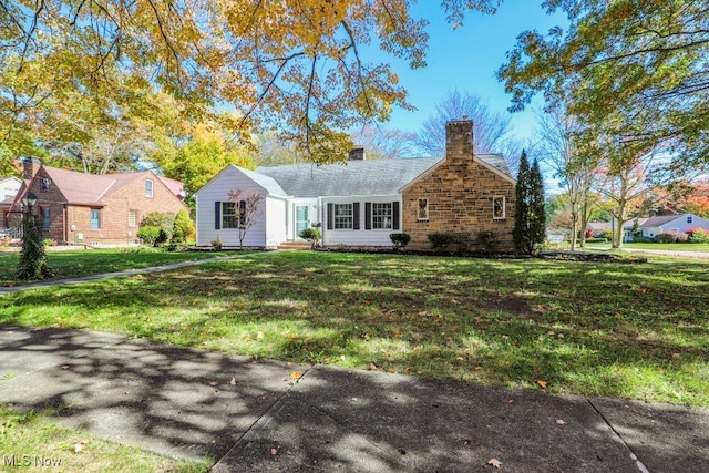 ranch-style house featuring a chimney and a front yard