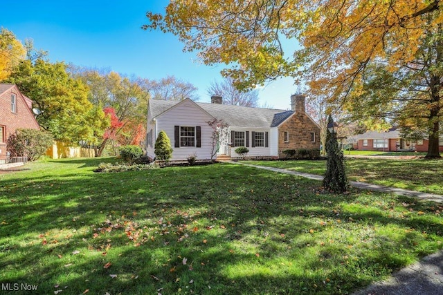 view of front of home with a front yard and a chimney