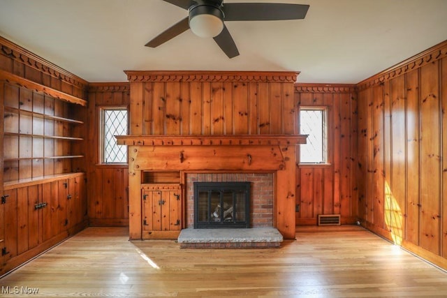 unfurnished living room featuring a ceiling fan, light wood-style flooring, and plenty of natural light