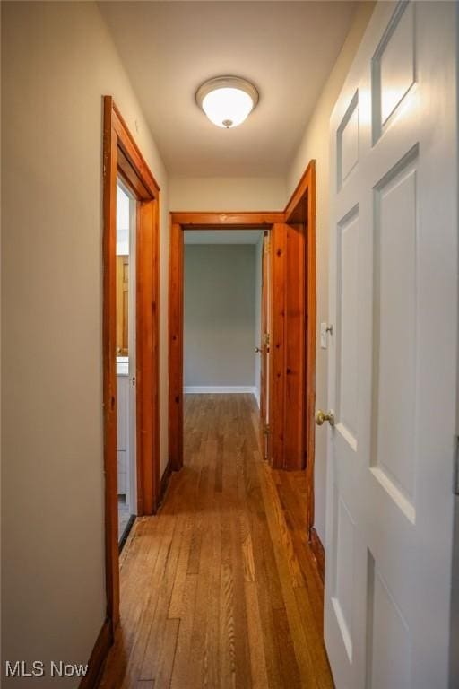 hall featuring wood finished floors and baseboards