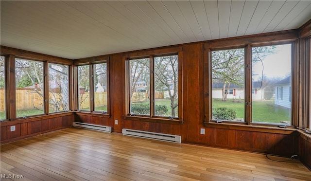 unfurnished sunroom with baseboard heating, a deck, and wood-type flooring