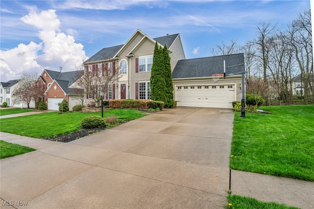 colonial home with a front lawn, driveway, and a garage