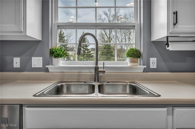 kitchen featuring a sink, white cabinets, a wealth of natural light, and light countertops