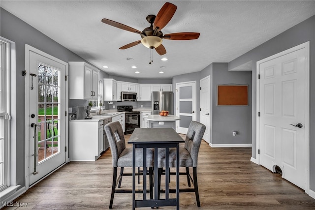 dining space with baseboards, recessed lighting, wood finished floors, and ceiling fan