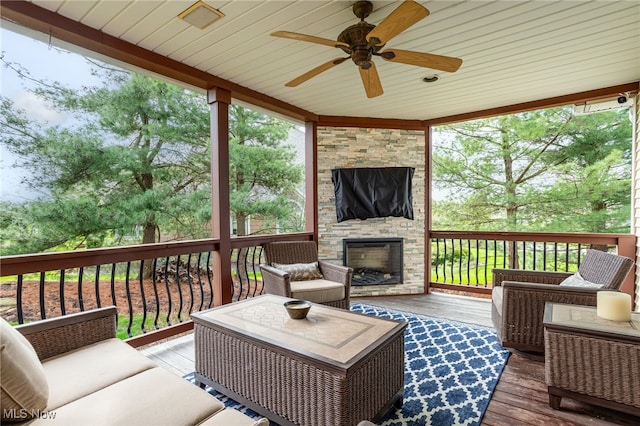 wooden terrace with an outdoor living space with a fireplace and ceiling fan
