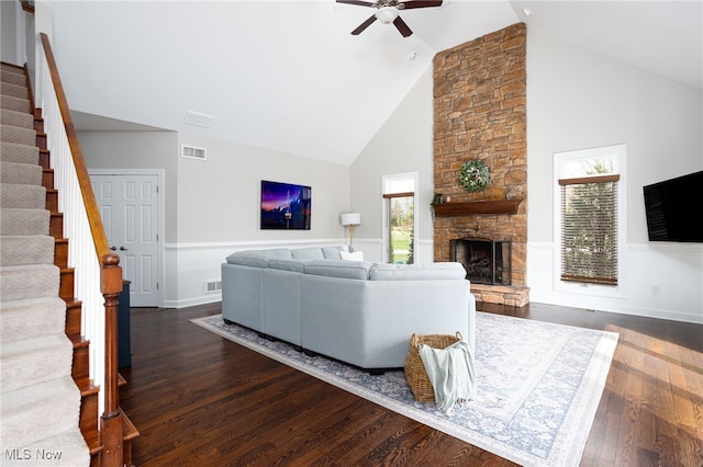 living area featuring dark wood finished floors, stairway, ceiling fan, visible vents, and high vaulted ceiling