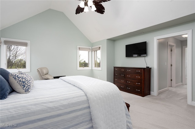 bedroom featuring a ceiling fan, vaulted ceiling, light colored carpet, and baseboards