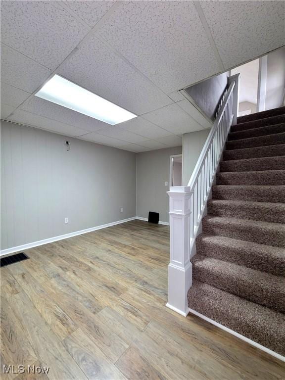 1024 Cleveland St SW, Massillon, OH 44647 - finished basement featuring stairs, a drop ceiling, wood finished floors, and baseboards