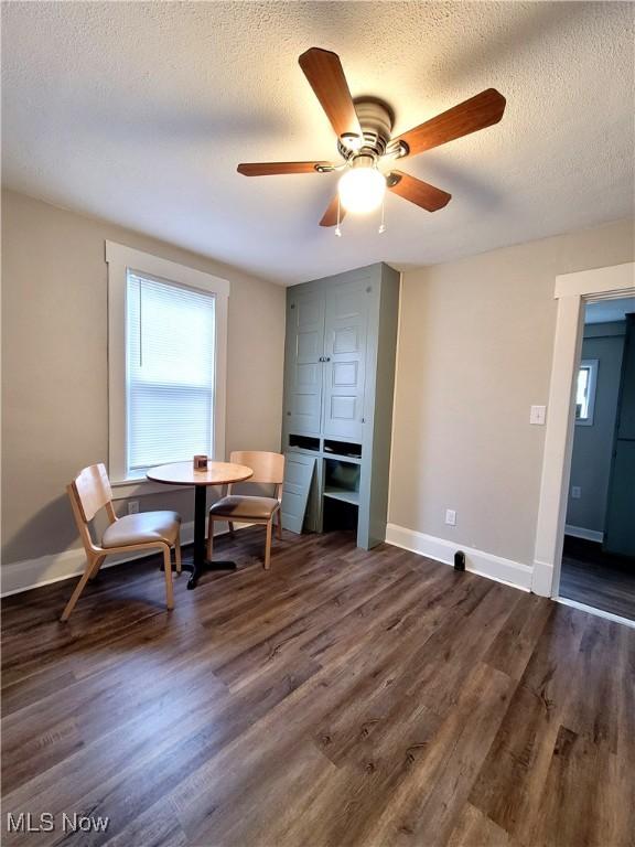 1024 Cleveland St SW, Massillon, OH 44647 - living area featuring a textured ceiling, dark wood-style flooring, ceiling fan, and baseboards
