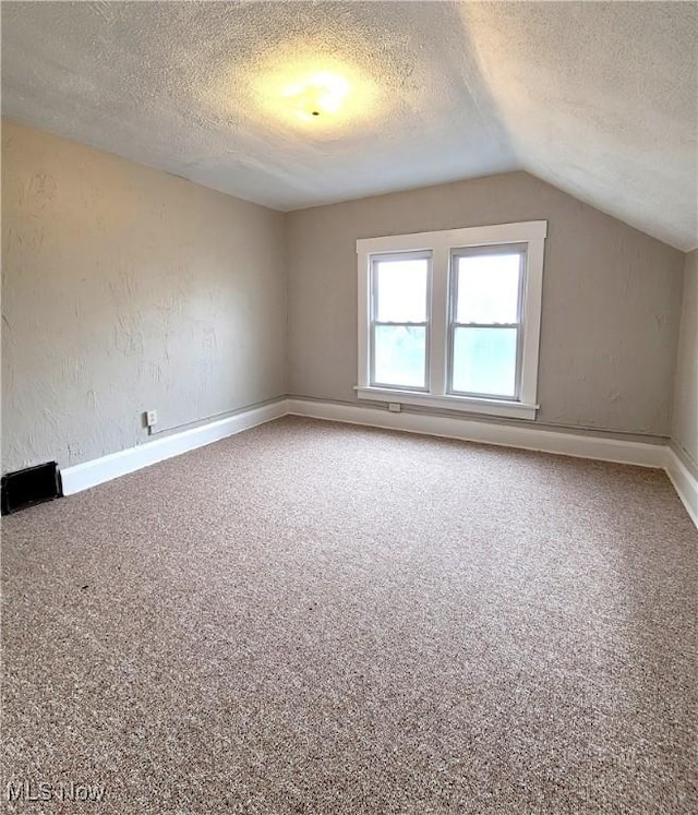 1024 Cleveland St SW, Massillon, OH 44647 - additional living space featuring baseboards, a textured ceiling, carpet flooring, and vaulted ceiling
