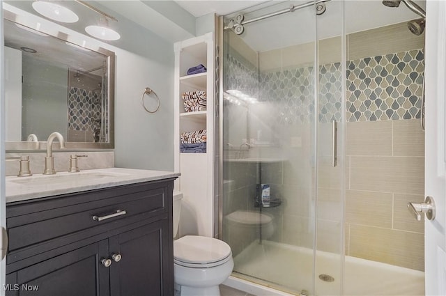 bathroom with vanity, toilet, and a stall shower
