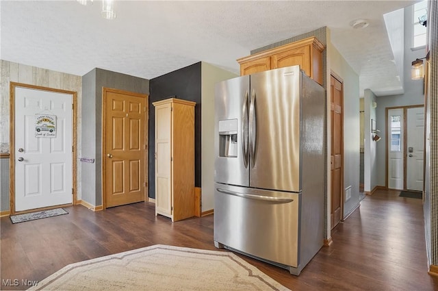 kitchen featuring stainless steel fridge, a textured ceiling, dark wood-style flooring, and baseboards