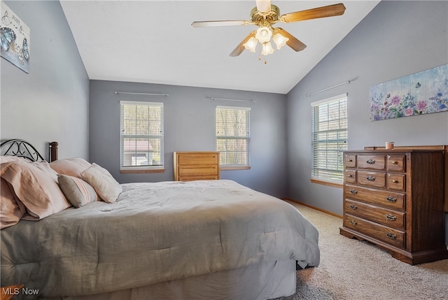 carpeted bedroom with multiple windows, ceiling fan, vaulted ceiling, and baseboards