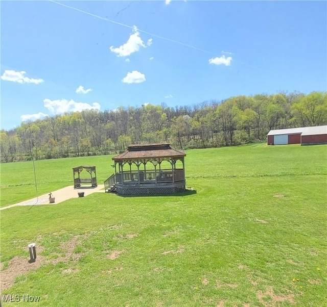 surrounding community featuring a lawn, a gazebo, and a view of trees