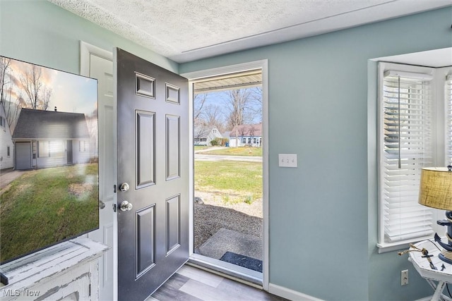 entrance foyer with baseboards and a textured ceiling
