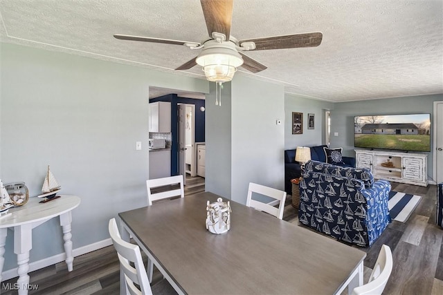 dining area with baseboards, wood finished floors, ceiling fan, and a textured ceiling