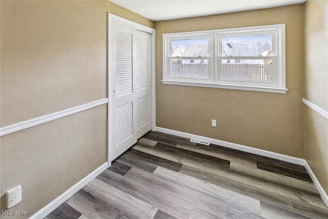 unfurnished bedroom with visible vents, a closet, baseboards, and multiple windows