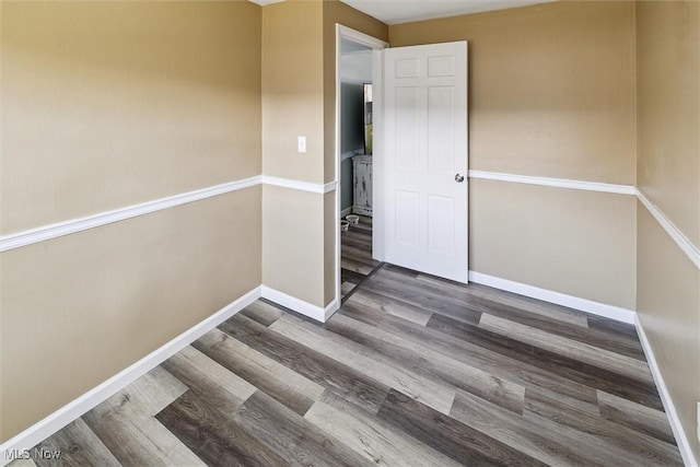 empty room featuring wood finished floors and baseboards