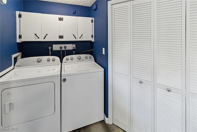 clothes washing area with dark wood-style floors, washer and dryer, and cabinet space