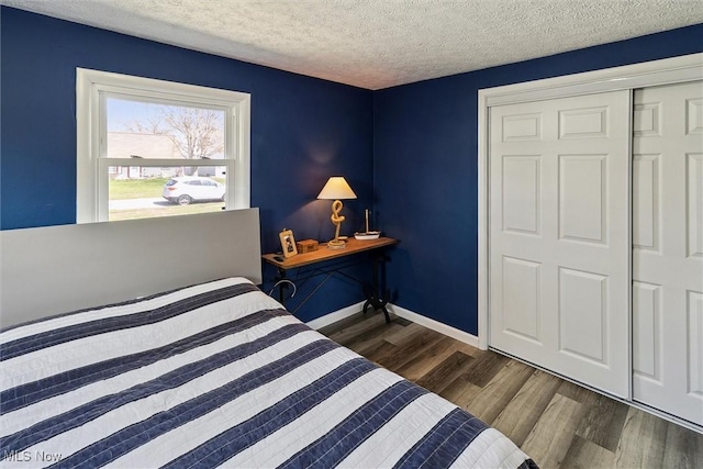 bedroom with baseboards, wood finished floors, and a textured ceiling