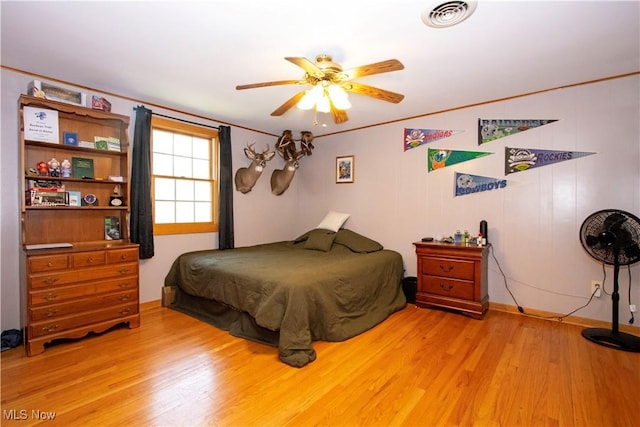 bedroom with visible vents, ceiling fan, light wood finished floors, and baseboards