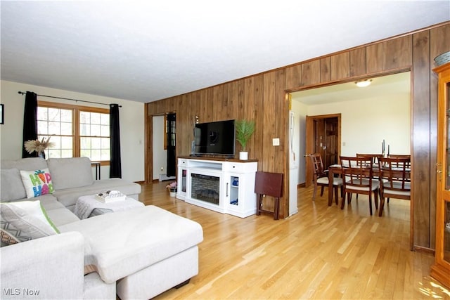 living room with wood walls and light wood-type flooring