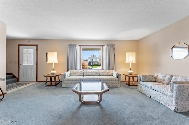 carpeted living area with stairs, a textured ceiling, and baseboards