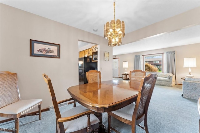 dining space with baseboards, a chandelier, and light carpet