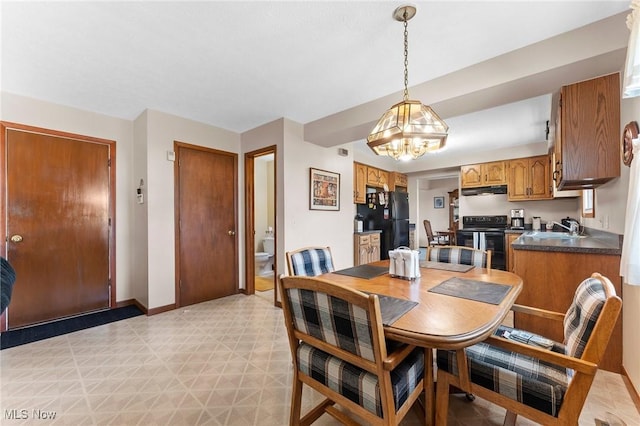 dining space with an inviting chandelier, light floors, and baseboards