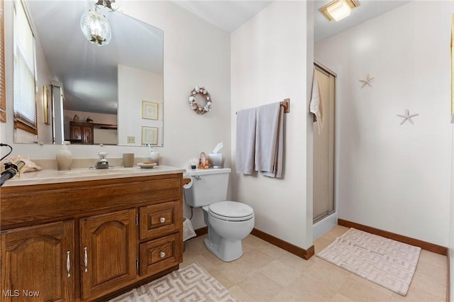 bathroom featuring vanity, toilet, baseboards, and a stall shower