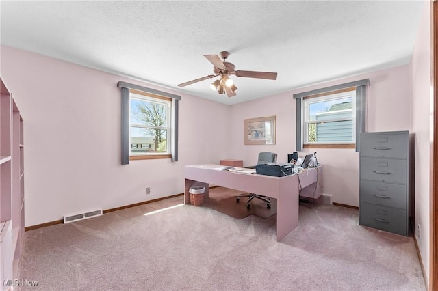 office space featuring visible vents, carpet flooring, baseboards, and a ceiling fan