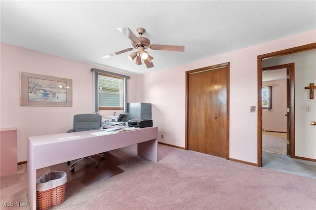 carpeted office with plenty of natural light, a ceiling fan, and baseboards