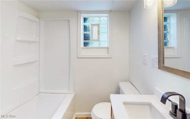 bathroom with toilet, vanity, and baseboards