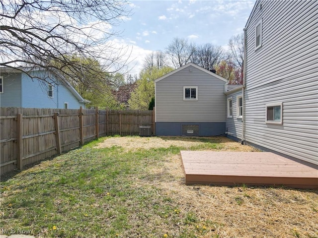 view of yard with central AC, a fenced backyard, and a deck