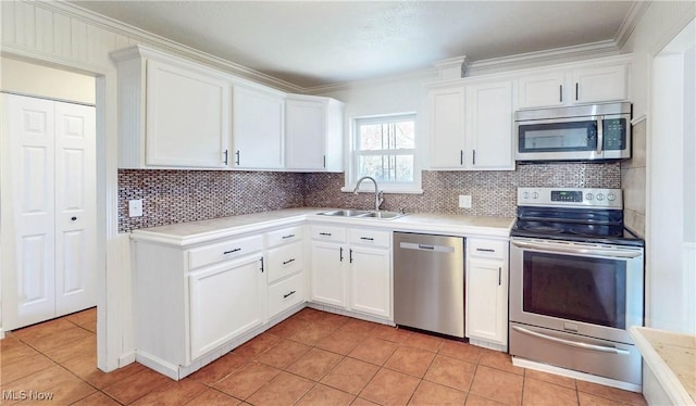 kitchen featuring a sink, stainless steel appliances, light tile patterned floors, white cabinetry, and light countertops