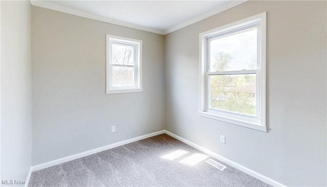 carpeted spare room with baseboards, visible vents, and crown molding