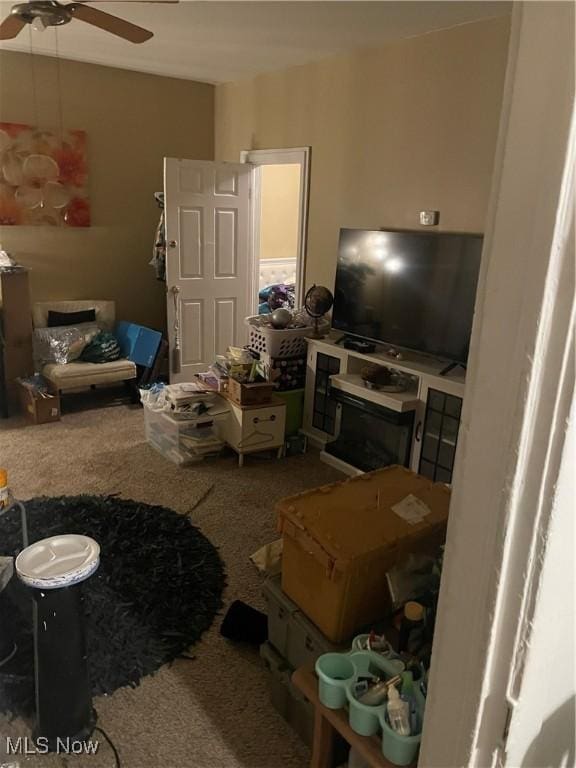 carpeted living area featuring ceiling fan