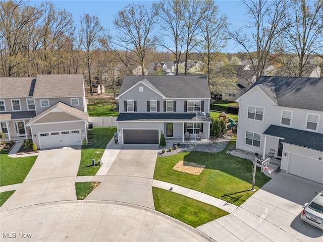 4591 Boulder Ln, Lorain, OH 44053 - traditional-style house with a residential view, concrete driveway, covered porch, a front lawn, and a shingled roof
