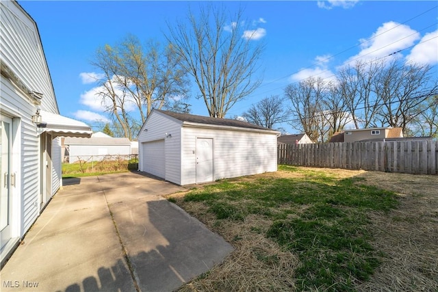 exterior space featuring an outbuilding, a detached garage, and fence