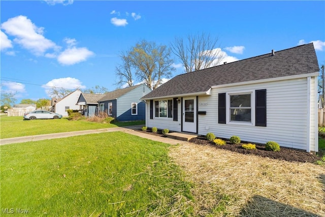 single story home with a front yard and a shingled roof